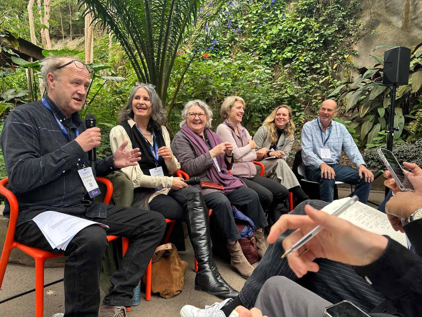Vibrant group discussion during Envisionation event at Rocio Bebraver, surrounded by lush greenery, fostering sustainable innovation and collaboration.