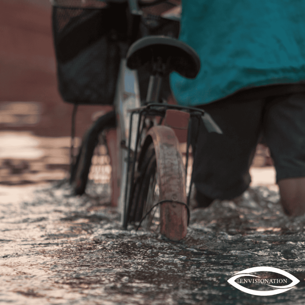 Flooded street with a bicycle submerged in water, highlighting urban flooding impacts and climate re.